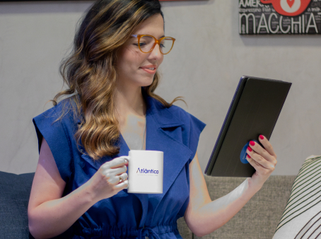 Mulher segurando tablet enquanto toma café